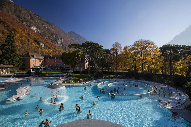 A thermal pool with clear water and people bathing.